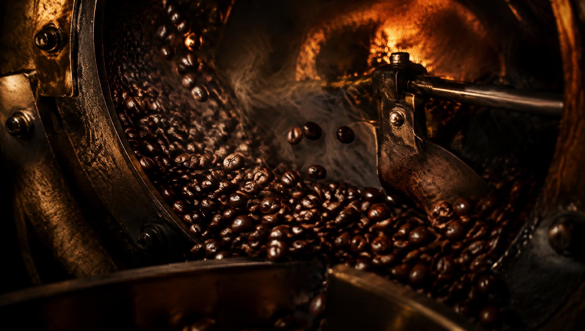 Coffee beans tumbling inside a glowing drum roaster
